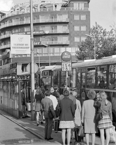 855037 Afbeelding van wachtende mensen bij een bushalte met abri voor de stadsbussen aan de noordzijde van het ...
